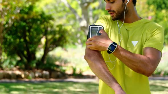 Jogger man touching the mp3 player in armband 4k alt