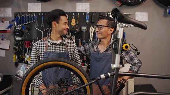 Portrait of Asian senior man and son owner bicycle shop smiling and looking at camera