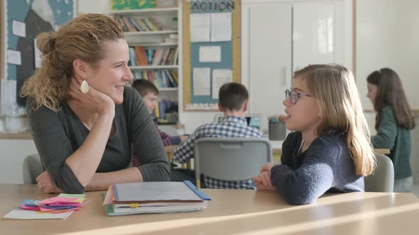 Girl speaking with teacher in classroom