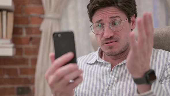 Portrait of Middle Aged Man Reacting to Loss on Smartphone alt
