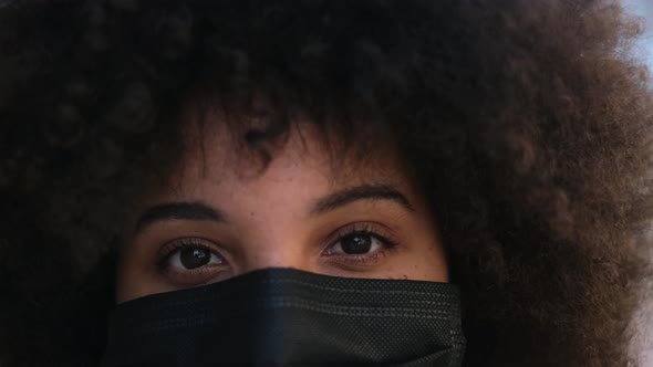 portrait of African or American young woman wearing medical mask to prevent covid-19
