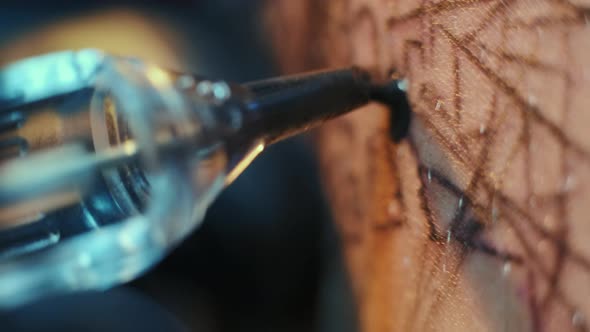 Close Up Shot of Magnum Bar Needles of Electric Tattoo Gun Filling Black Pattern