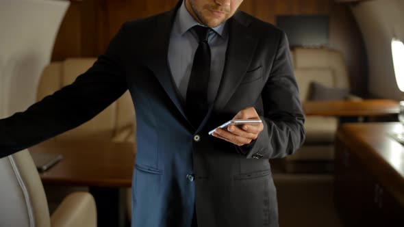 Entrepreneur with Smartphone Inside of Private Jet. alt