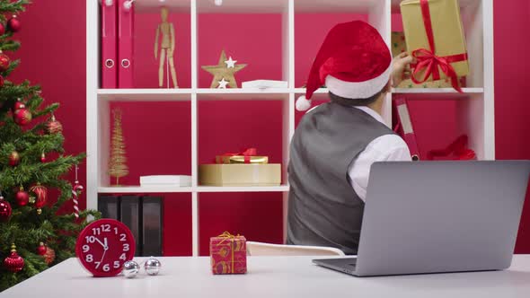 Santa Claus Assistant in Office Concept. Cheerful 40s Man Has Fun Sorting Gifts