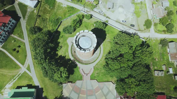 Flight Over A Provincial Town. An Ancient Tower Among The Multi Colored Roofs Of Houses alt