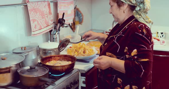 Grandma Fries the Dough in a Pan Stirs the Butter with a Spoon alt
