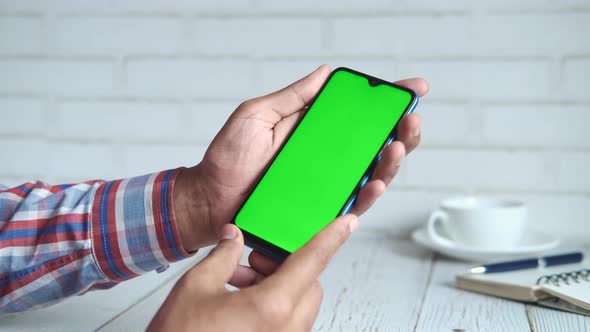 Close Up of Young Man Hand Using Smart Phone with Green Screen alt