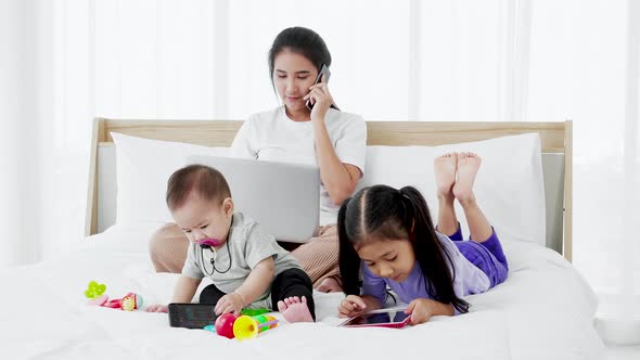 Asian Young mother on maternity leave trying to freelance with toddler child