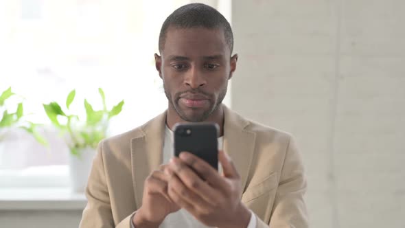 Portrait of African Man Using Smartphone alt