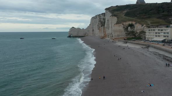 Etretat Cliffs on Stormy, Cloudy Day with People on the Beach and Oceanview alt