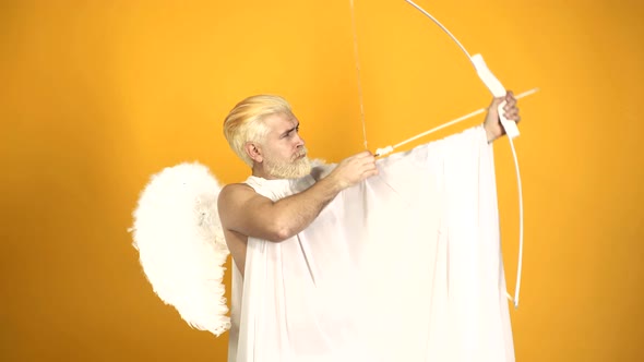 Valentine's Day. Cupid Man Holding Bow and Aiming or Shooting Arrow. alt
