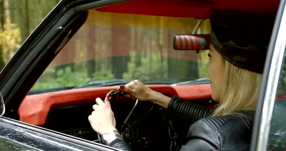 Happy Blonde Woman Is Sitting on Driver's Seat in Her Luxury Car and Smiling alt