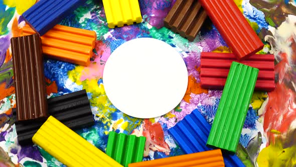 Multi-colored pieces of plasticine, cardboard with plasticine abstraction rotate on a turntable
