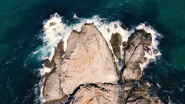 waves crashing cliffs view from drone shot alt