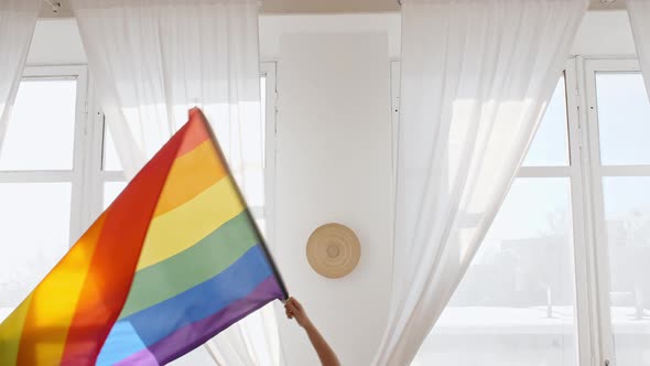 Rainbow LGBT Flag in Hand and Waving on Sunset in Sunny Rays alt