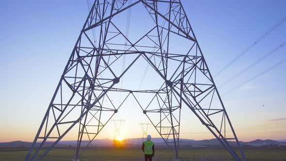 Engineer walking towards electric pole extension. alt