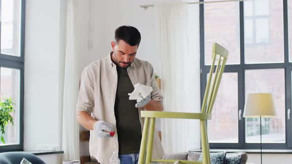 Man Applying Solvent to Rag and Cleaning Old Chair alt