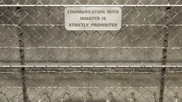 View at the fence with prison building. Barbed wires. Cameras. Danger zone 4k HD alt