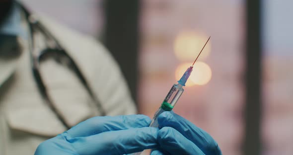 The Doctor Holds a Syringe with a Vaccine in His Hands