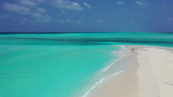Beautiful fly over clean view of a white sandy paradise beach and blue water background  alt