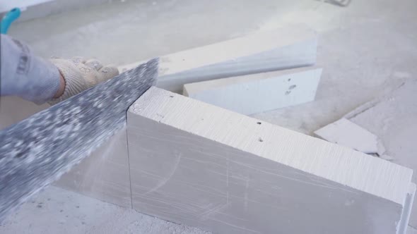 Beauty Slow Motion in Construction and Repair - Male Builder Sawing Gypsum Tongue-and-groove Blocks