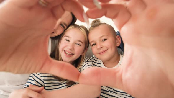 Close Up Portrait of Happy Young Family Making Heart Gesture with Fingers Showing Love for Family alt