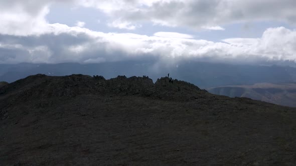 Aerial view of a green hill pick on cloudy sky background alt