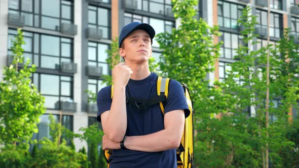 Thoughtful Man Courier with Backpack Looks Around Looking Delivery Address alt