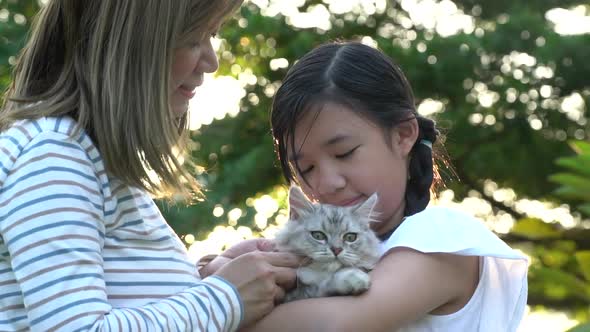 Asian Mother Playing A Kitten To Her Daughter  alt