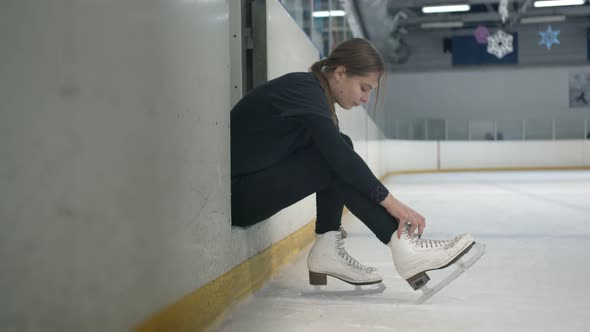 Young Woman Tying Shoelaces on Her Skates