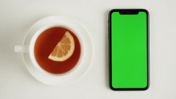 Black Tea and Smartphone with Green Chroma Key Screen Top View alt