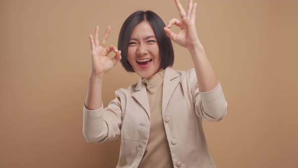 Asian business woman happy smiling show her hands in OK sign language isolated