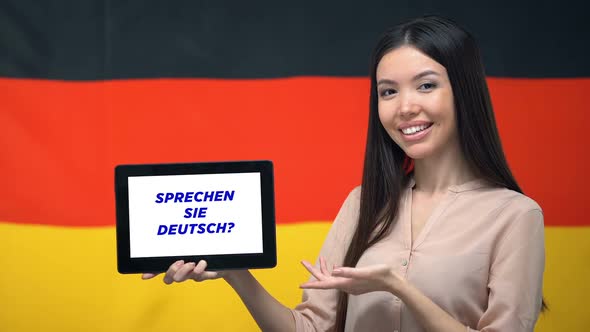 Woman Holding Tablet With Do You Speak German Phrase, App for Learning Language alt