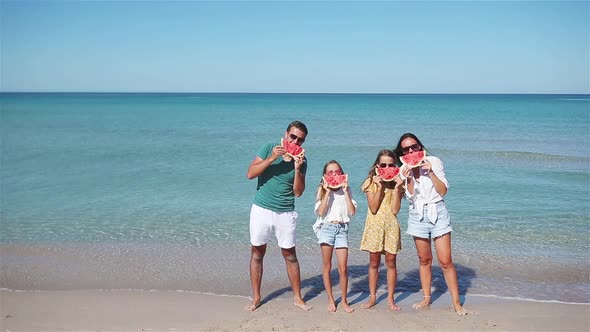 Happy Family Eating Watermelon on the Beach.