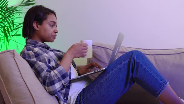 AfricanAmerican Woman in Casual Clothes Using a Laptop Running