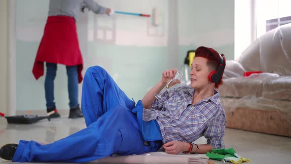Wide Shot Relaxed Woman in Headphones Drinking Champagne Listening to Music with Unrecognizable alt
