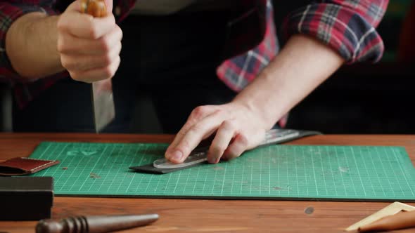 Man Tailor Cutting Artificial Leather with Stencil Closeup alt