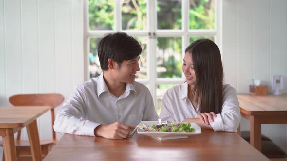 Happy couple posing taking selfie together use smartphone enjoying romantic date at restaurant. alt