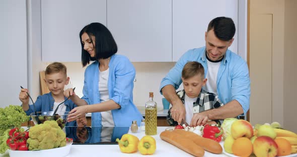 Family with Children which Having Fun Together while Cooking Useful Natural Vegetable Salad alt