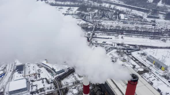 Two Smoking Factory Pipes in Front of the Panorama of Stretching Widely Industrial City. alt