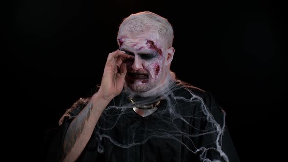 Upset Halloween Zombie Man Wipes Tears and Cries From Despair Being Sad Because of Unfair Things alt