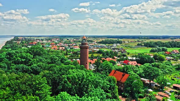 Lighthouse by forest and Baltic Sea in Poland, aerial view alt