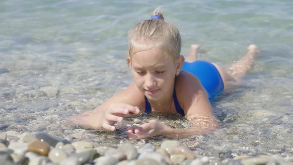Cute Child Girl Bathes in Sea. Family Vacation Concept. alt