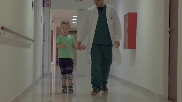 Doctor and child walking in hospital corridor alt