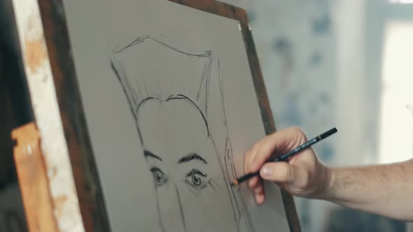 The Artist Is Working on a Painting on the Easel in the Workshop with a Pencil alt