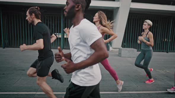 Black Man and His Team of Athletes Running Through the Stadium alt