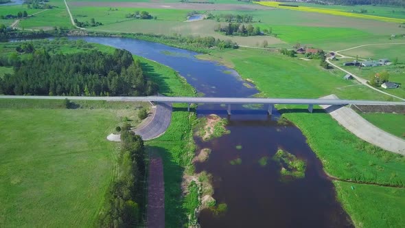 Aerial view of a Venta river (Latvia) on a sunny summer day, lush green trees and meadows, beautiful alt