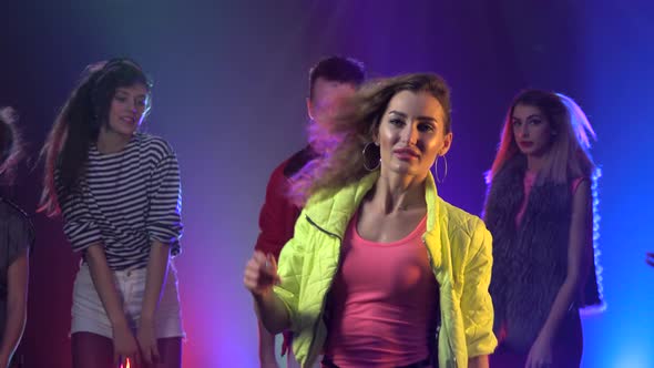 People Joyful and Dancing at a Nightclub Glowing Strobe Lights. Smoke Background alt