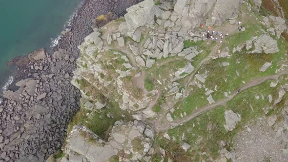 Top down aerial tracking backwards across the top of the rocky crag at the Valley of Rocks. Charity alt