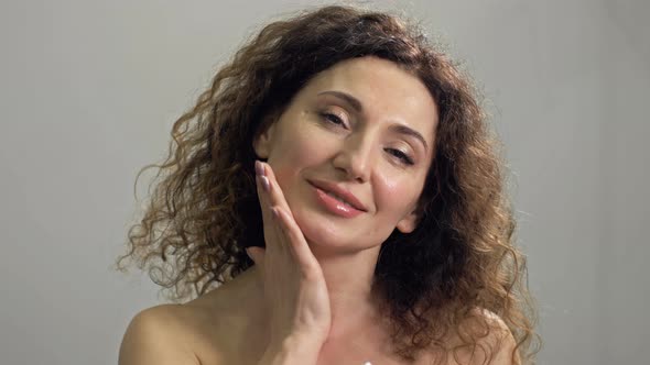 Beautiful Middleaged Woman Massages Her Neck with Light Movements alt